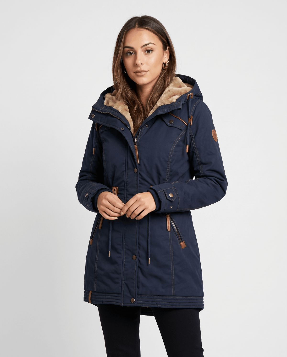 A woman wearing a navy blue winter parka jacket with a hood, plush lining, and drawstring waist