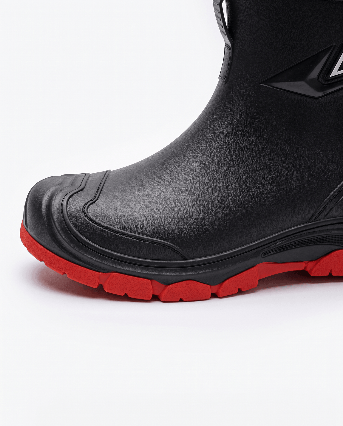 Close-up of the molded rubber toe guard and red lug sole edge