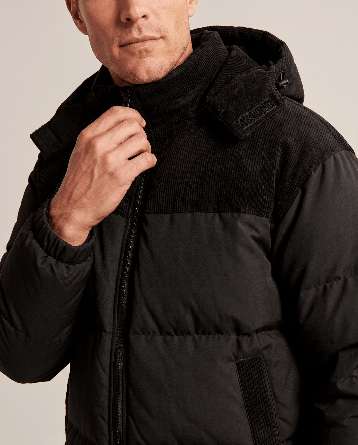 Close-up of black Dravon puffer jacket corduroy collar and zip