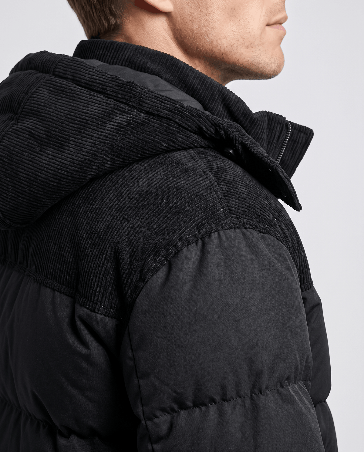 Close-up of black Dravon puffer jacket corduroy hood and padded shoulder