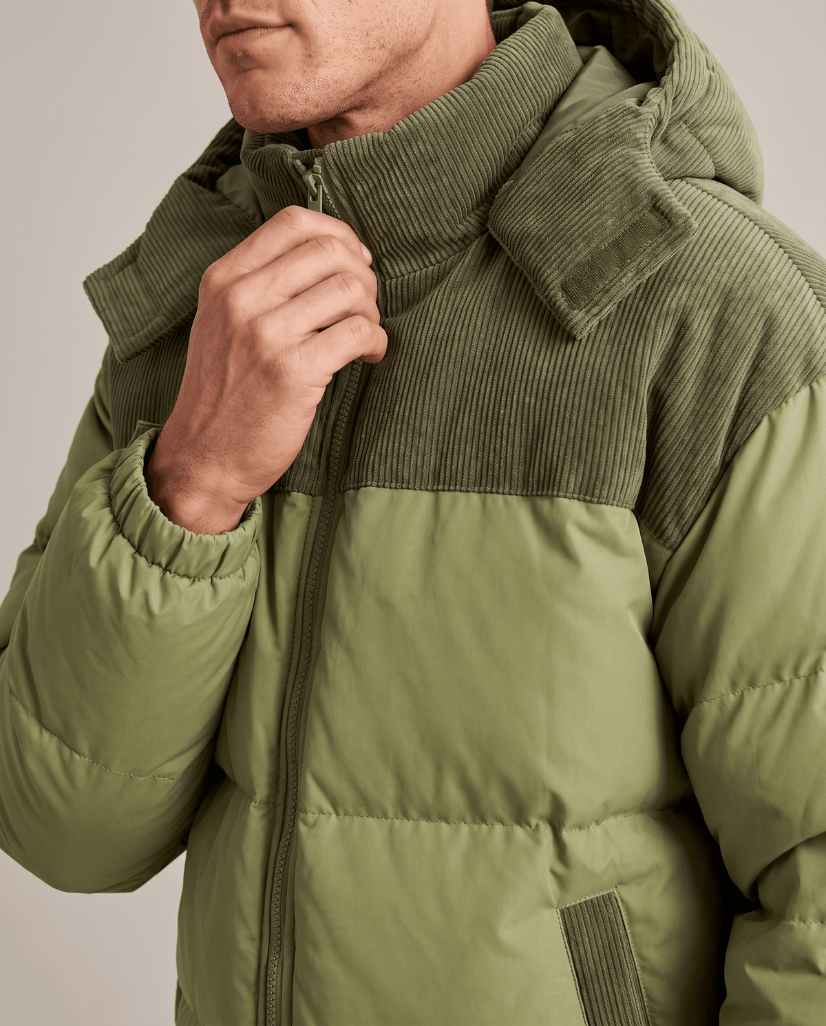 Close-up of green Dravon puffer jacket corduroy collar, hood and zip