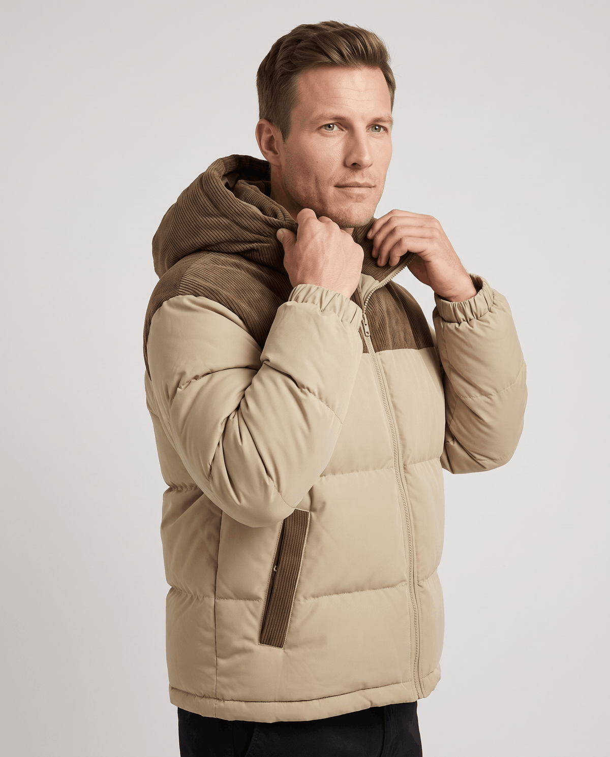Man adjusting the corduroy collar of a khaki Dravon two-tone quilted puffer jacket