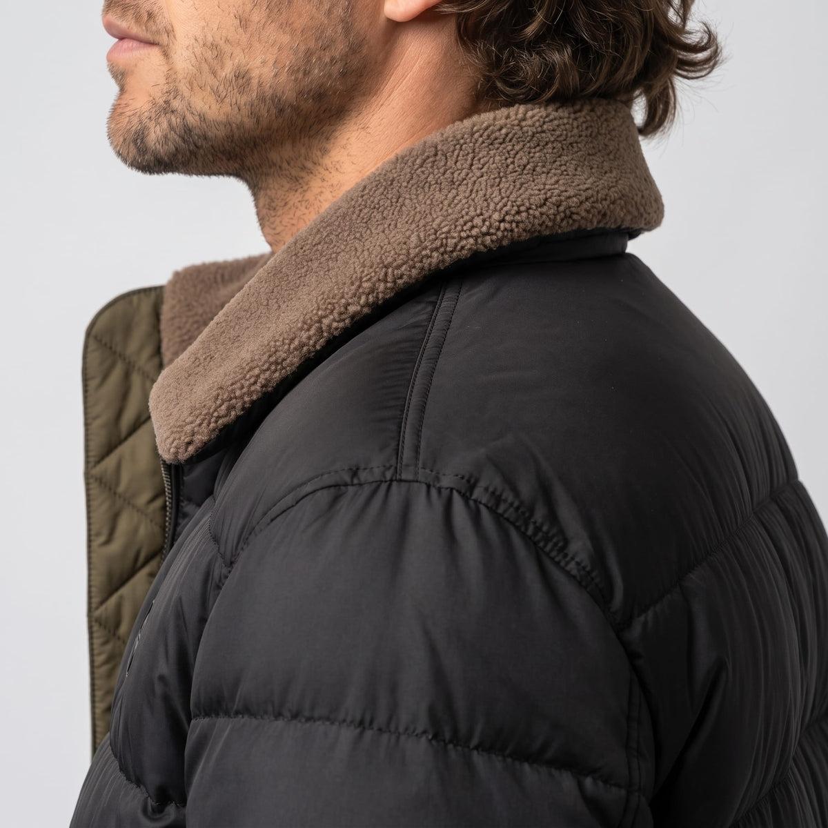 Close-up of black Julian puffer jacket fleece collar and quilted shoulder from behind