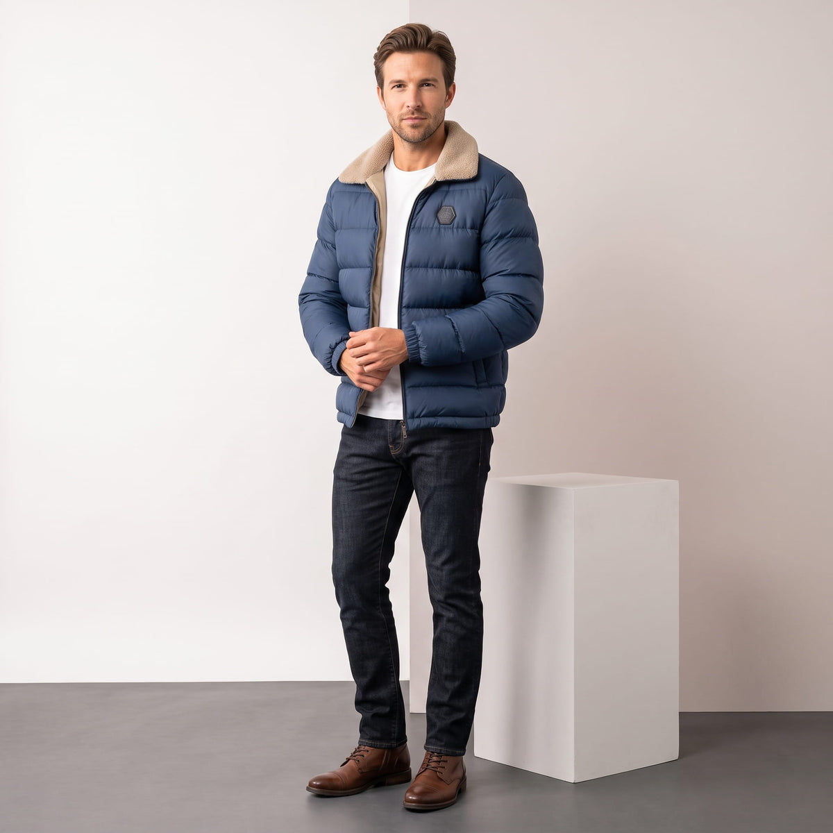 Man wearing navy blue Julian insulated puffer jacket with dark jeans, full-length front view