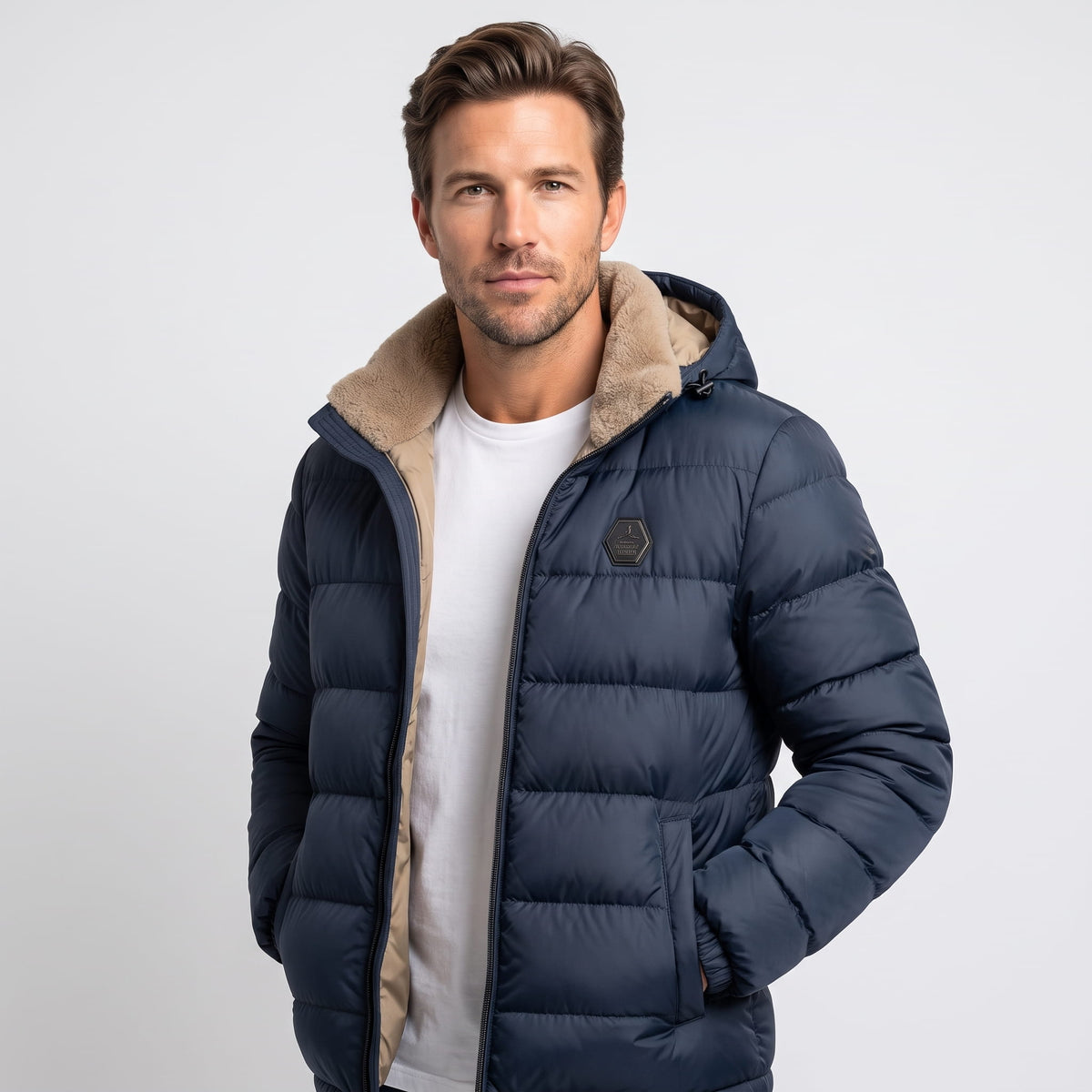 Man wearing navy blue Julian puffer jacket, waist-up front view with hands in pockets