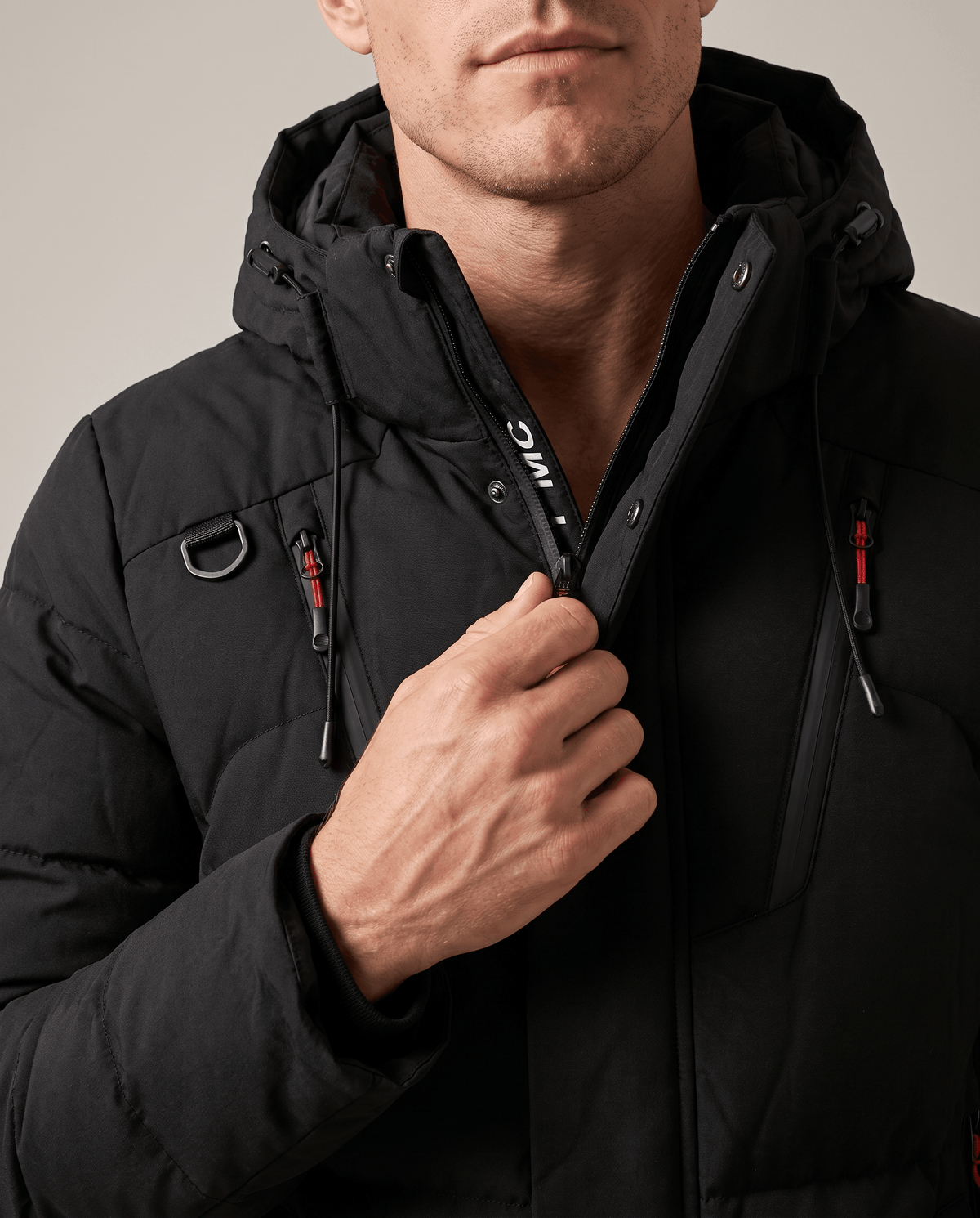 Close-up of black Paolo puffer jacket high collar, hood and zip pocket detail