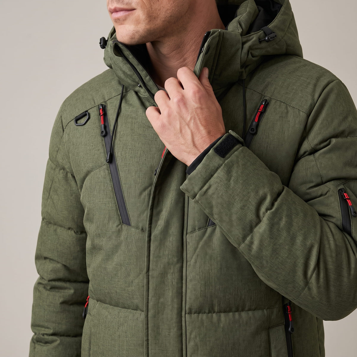 Close-up of green Paolo puffer jacket collar, hood and zip chest pocket detail