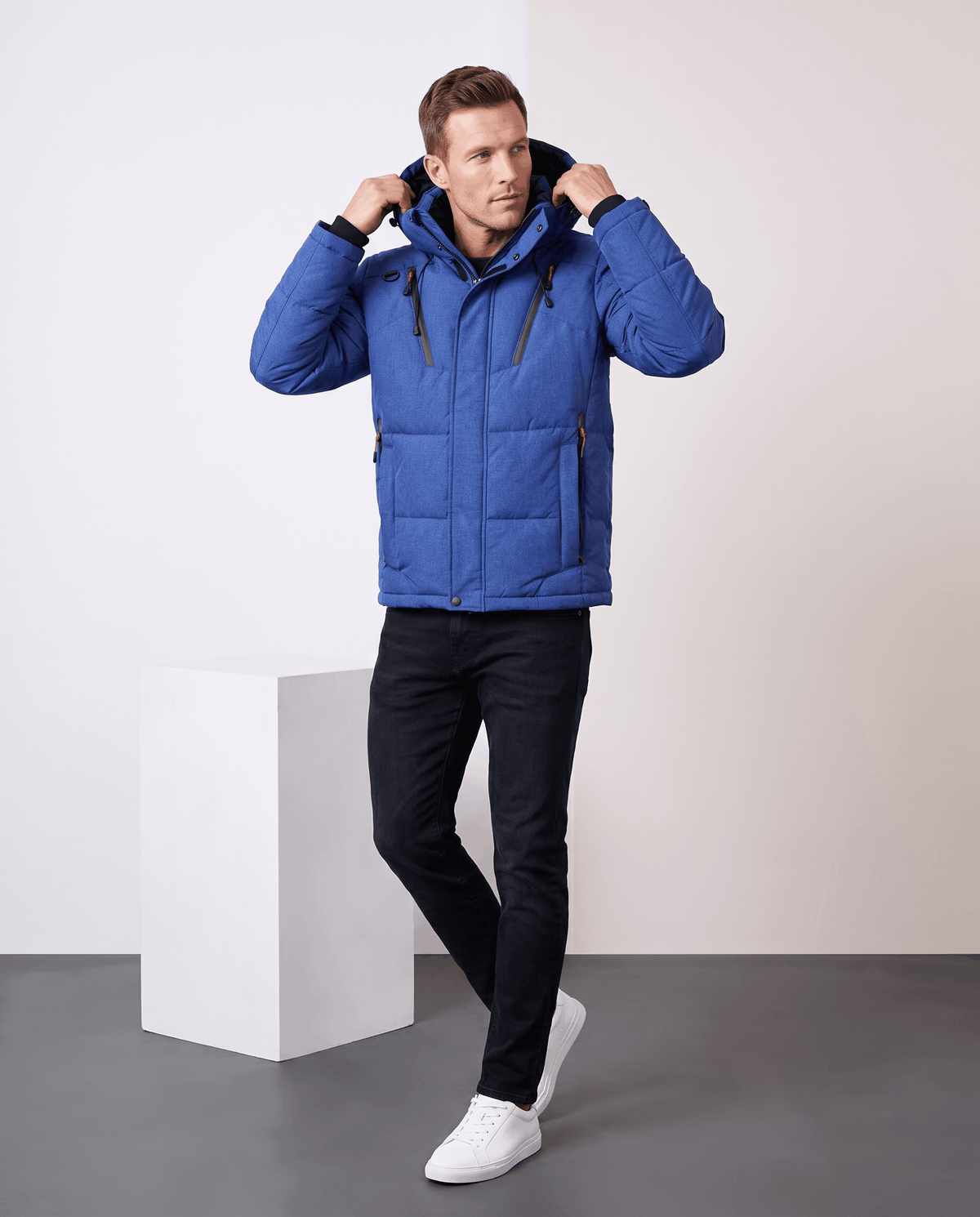 Man wearing navy blue Paolo hooded puffer jacket with black jeans, full-length front view