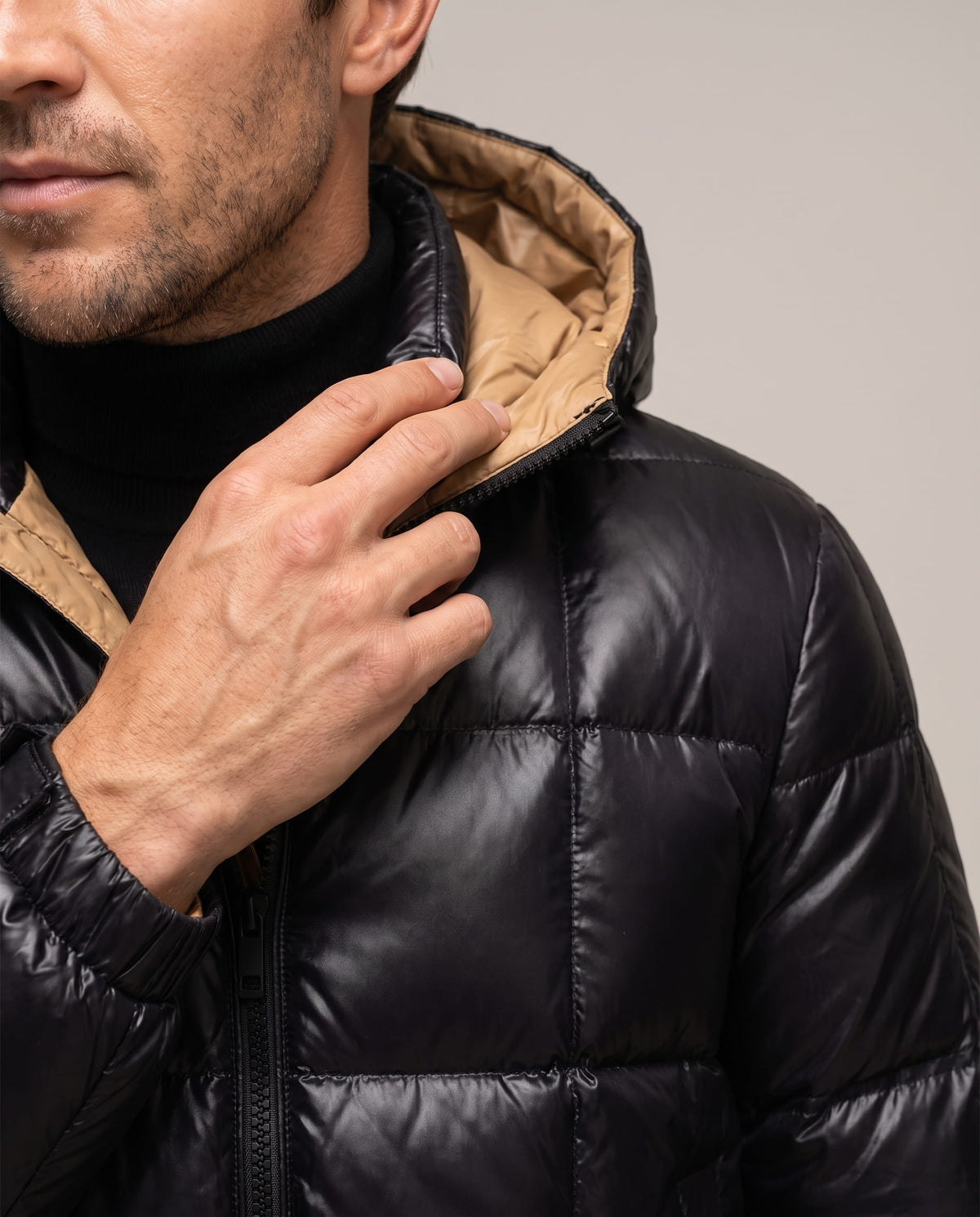 Close-up of black Robin puffer jacket collar, hood lining and glossy shell