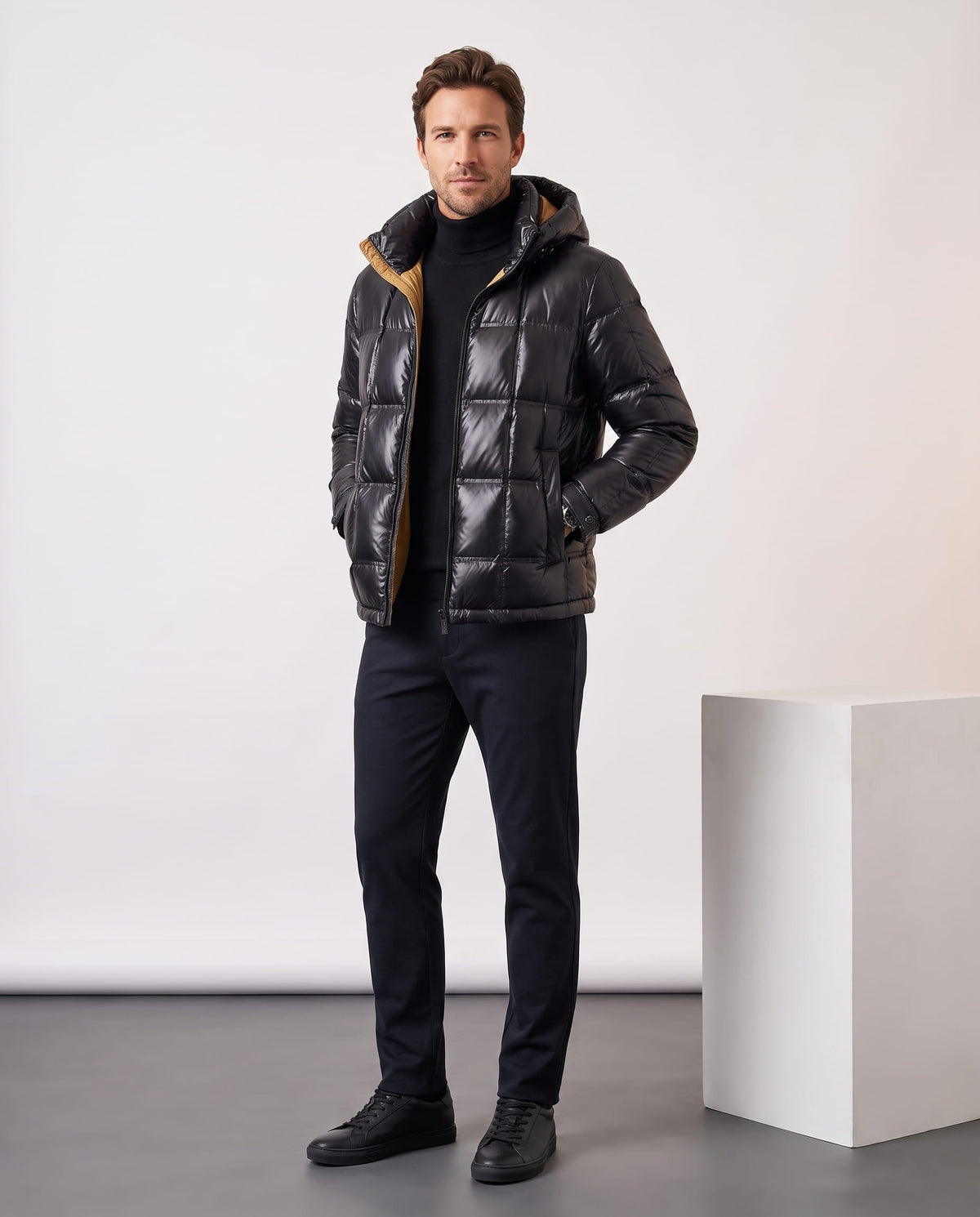 Man wearing black Robin hooded puffer jacket with dark trousers, full-length front view