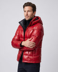 Man wearing red Robin hooded puffer jacket, three-quarter view with arms crossed