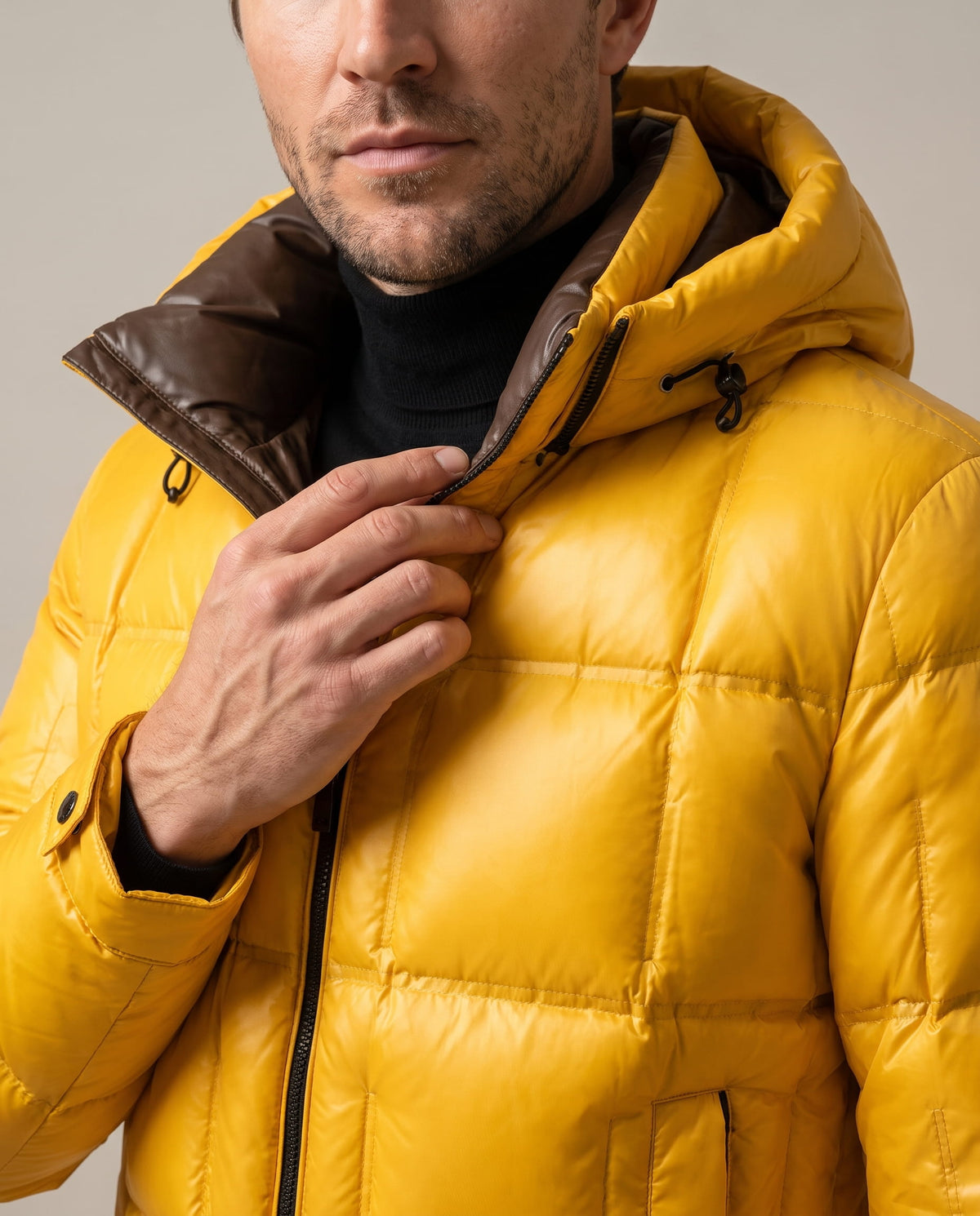 Close-up of yellow Robin puffer jacket collar, brown hood lining and zip