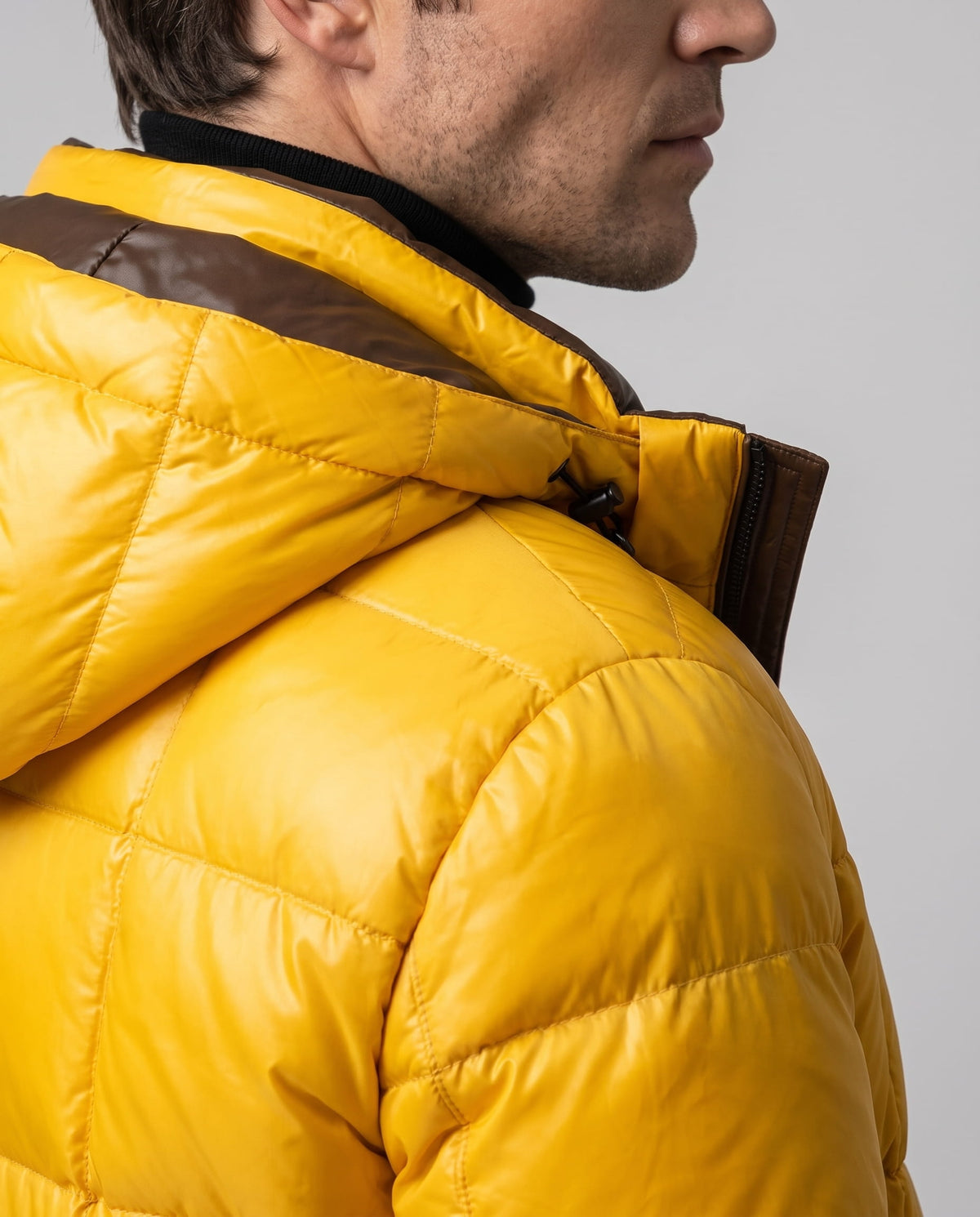 Close-up of yellow Robin puffer jacket hood and padded shoulder from the side