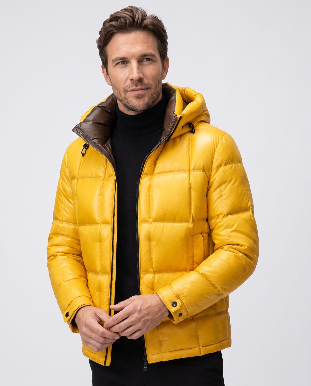 Man wearing yellow Robin down-filled puffer jacket, front view with brown hood lining