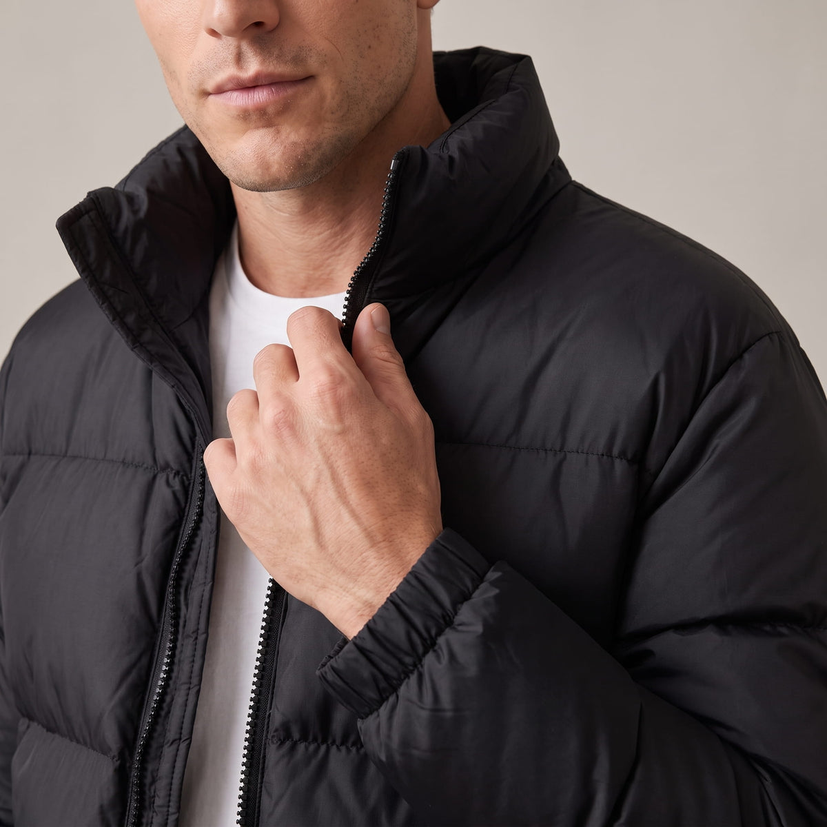Close-up of black Salvador puffer jacket high collar and full-length zip