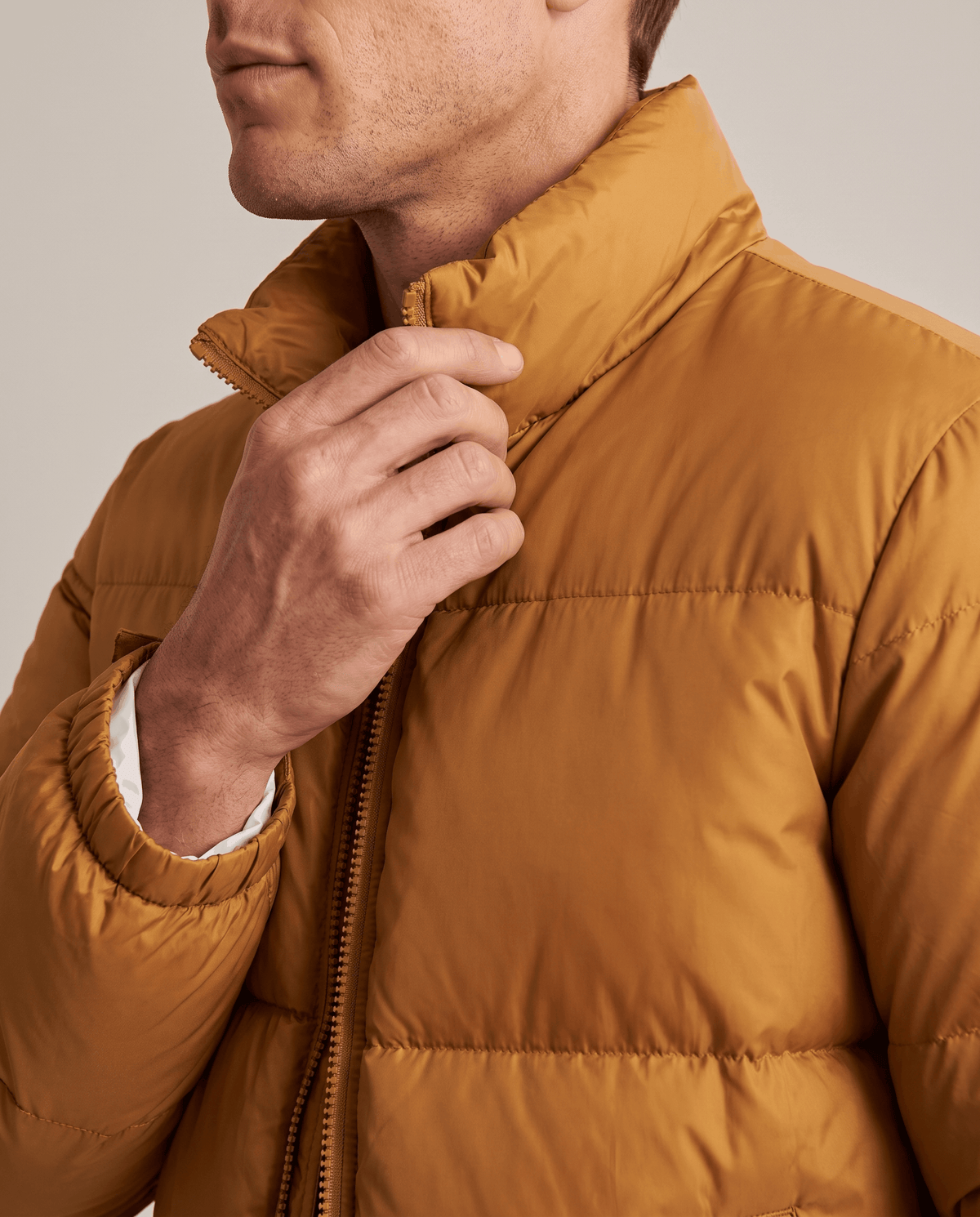 Close-up of caramel Salvador puffer jacket high collar and full-length zip