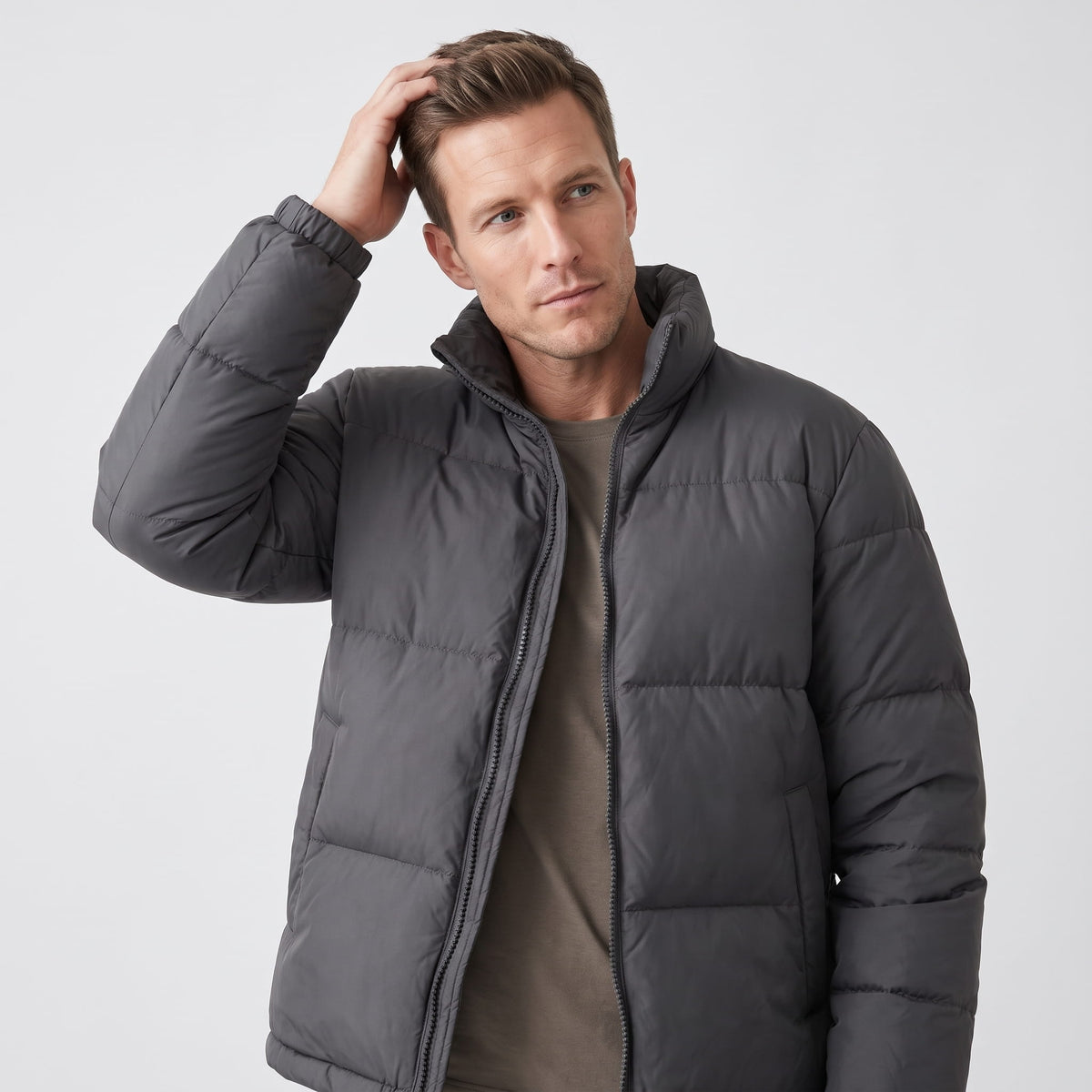 Man wearing dark gray Salvador quilted puffer jacket, front view with full-zip and high collar