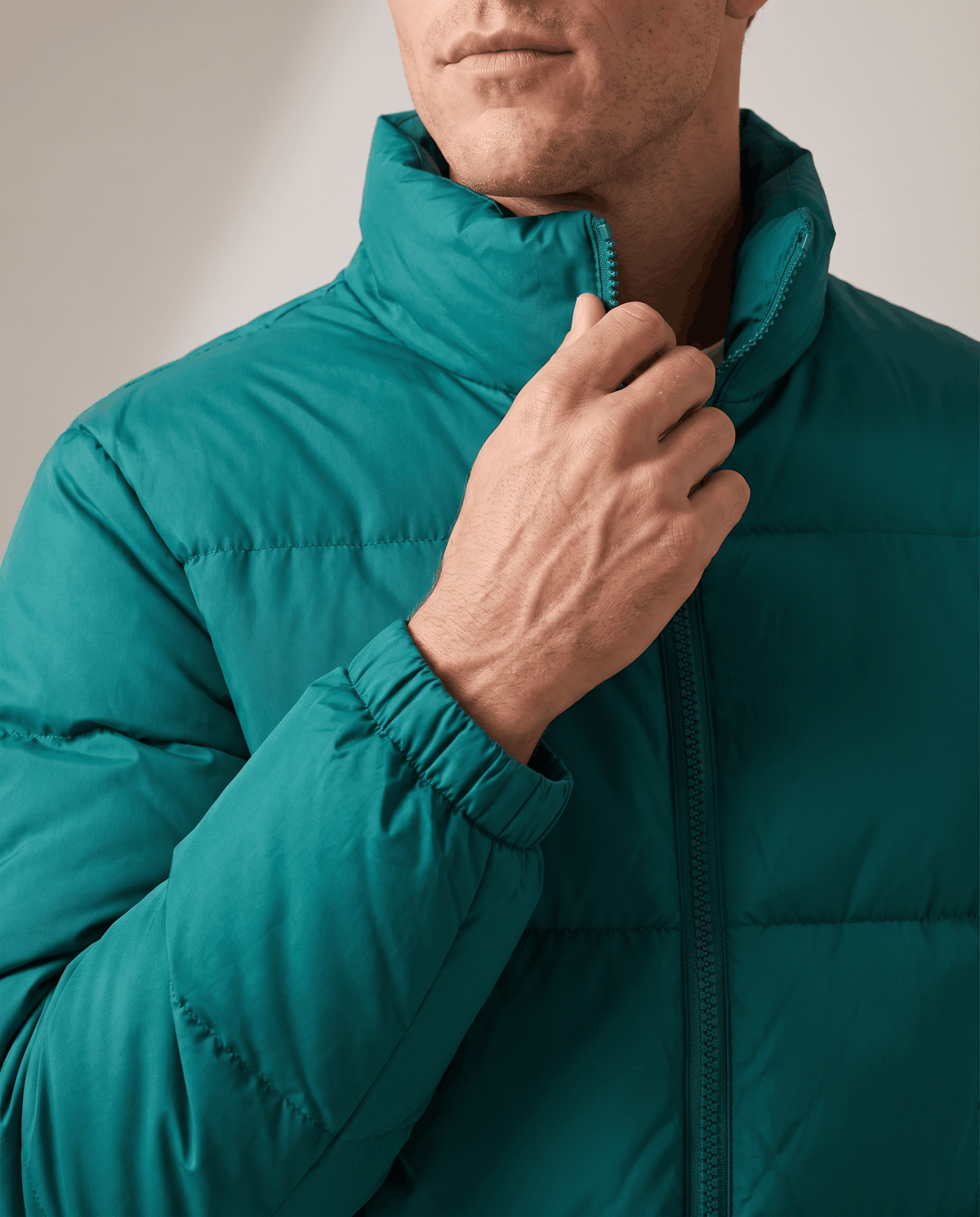 Close-up of deep teal Salvador puffer jacket high collar and full-length zip