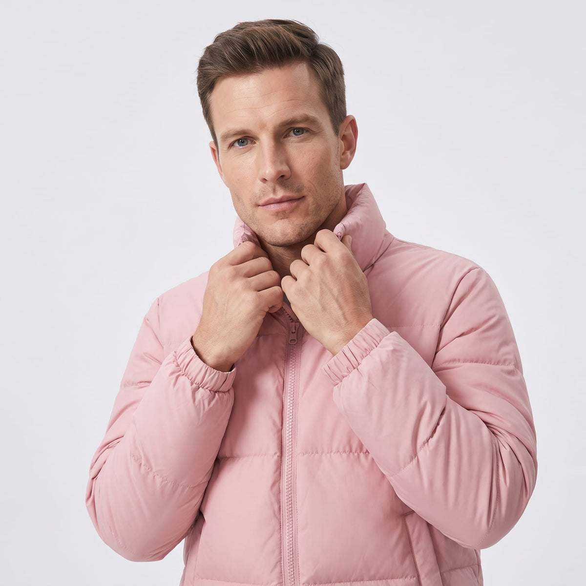 Man holding the high collar of a dusty pink Salvador quilted puffer jacket