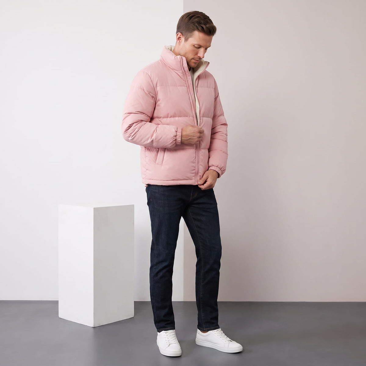 Man adjusting the zip of a dusty pink Salvador quilted puffer jacket, full-length view
