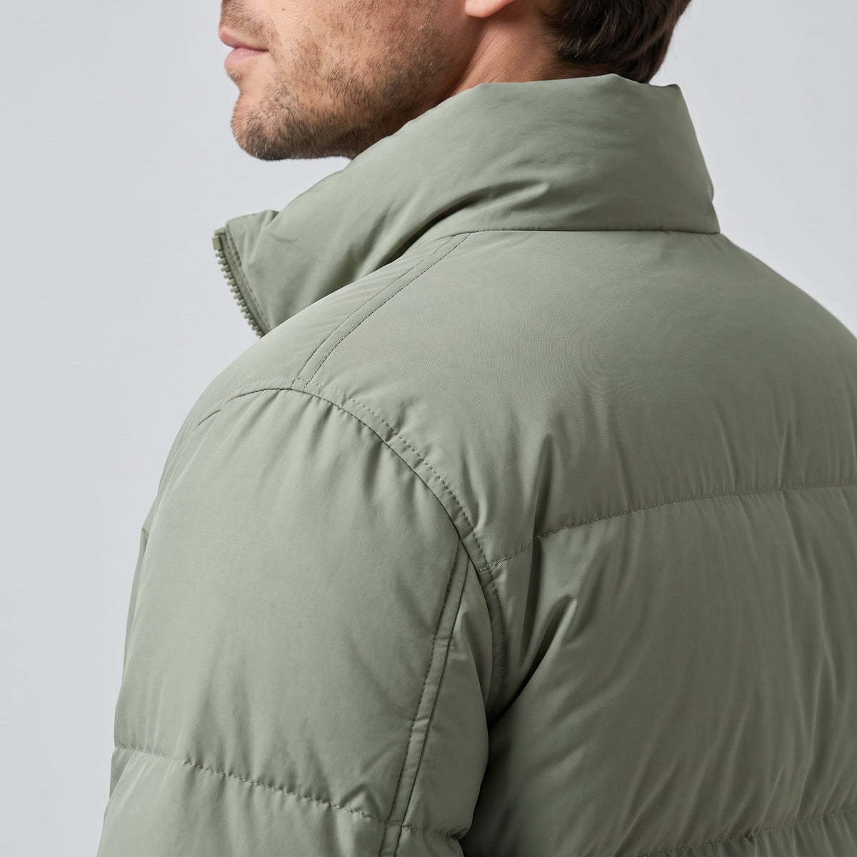 Close-up of sage Salvador puffer jacket high collar and quilted shoulder panel