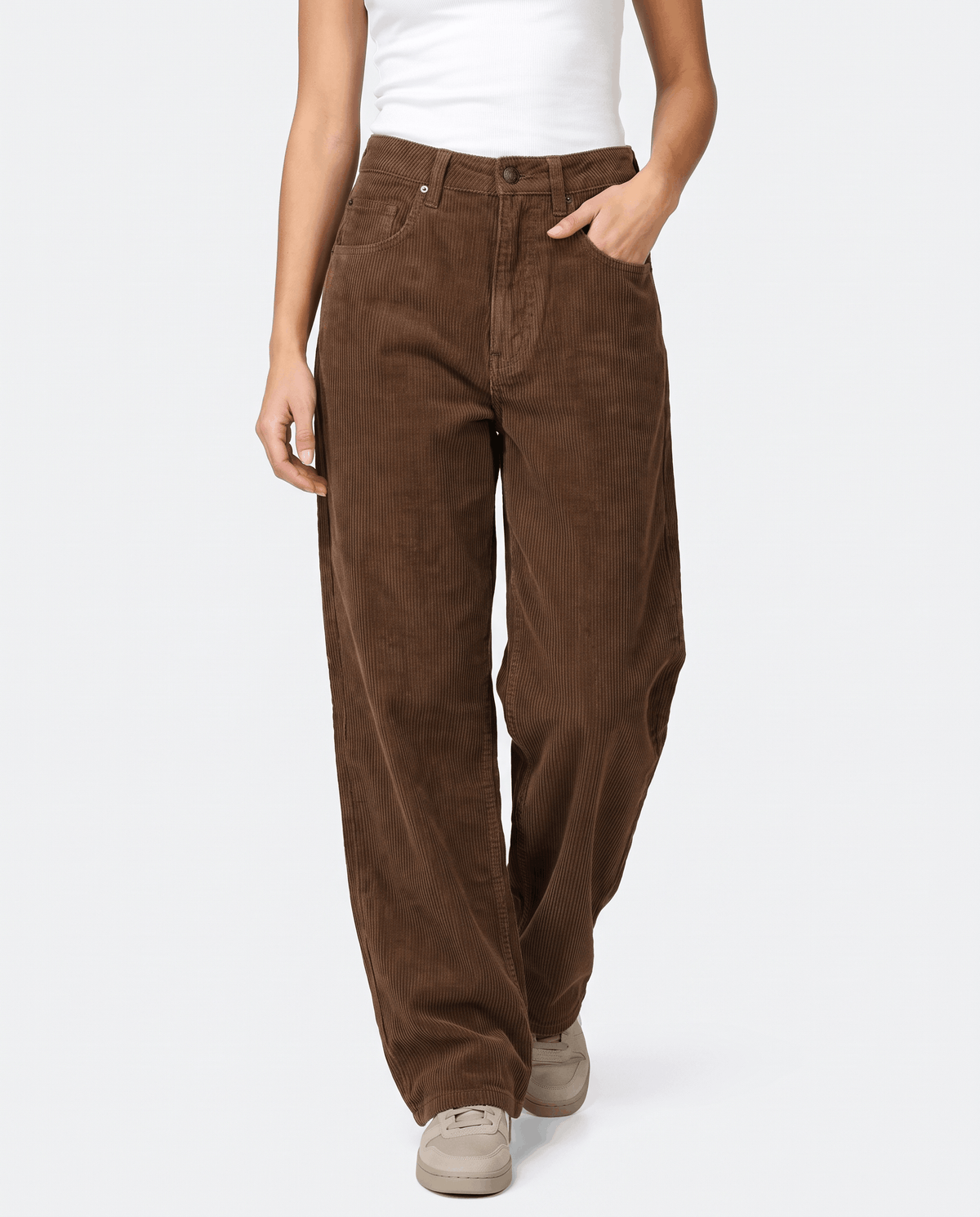 Woman wearing brown baggy wide-leg corduroy pants with beige sneakers, front view