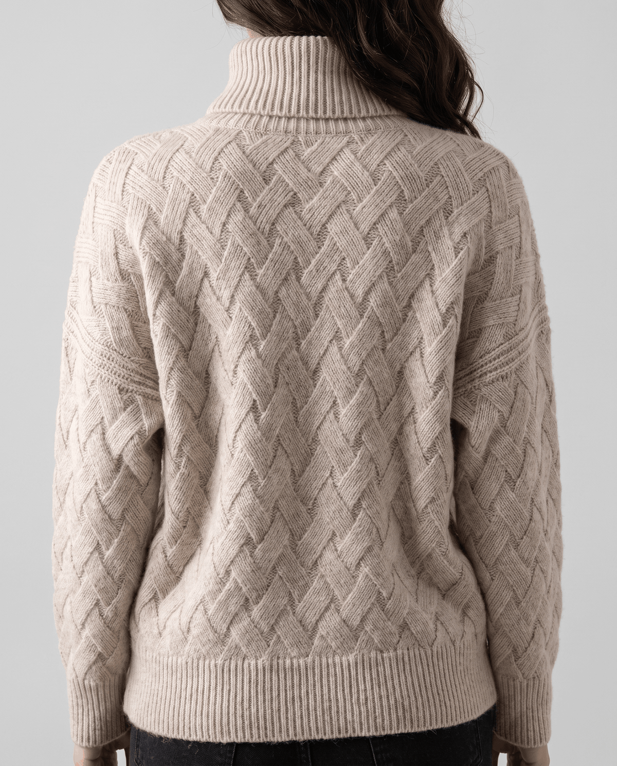 Back view of beige textured knit sweater with tall collar and ribbed hem