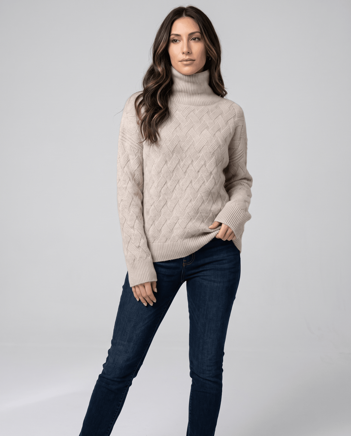 Model with hand in jeans pocket wearing a heathered beige textured turtleneck
