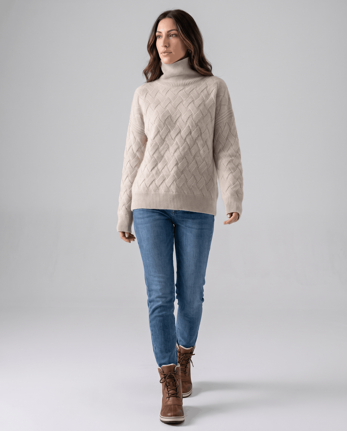 Full-length view of beige turtleneck sweater with light jeans and ankle boots