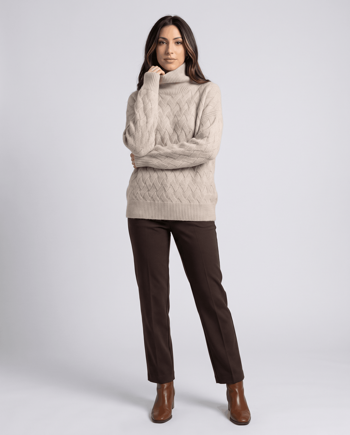 Full-length view of beige turtleneck sweater with brown trousers and boots