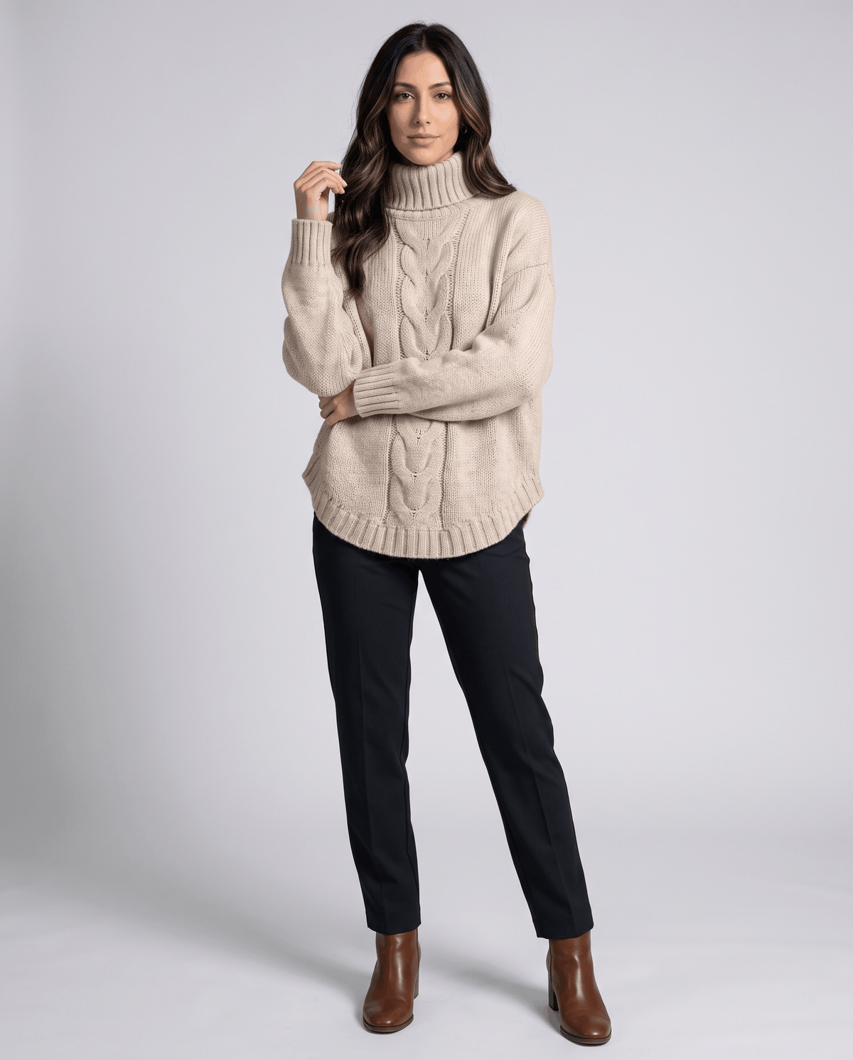 Full-length view of beige turtleneck sweater with black pants and brown boots