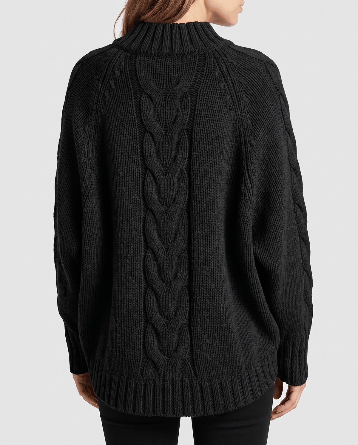 Back view of black batwing sweater showing cable panel and ribbed hem
