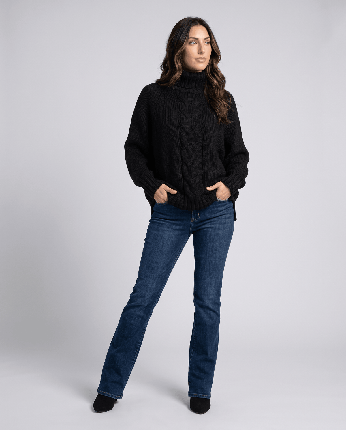 Full-length view of black turtleneck sweater with bootcut jeans