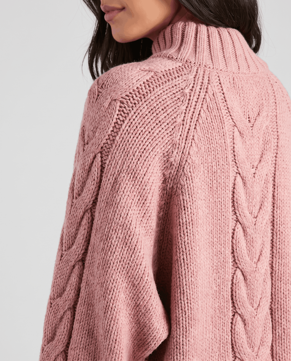 Back shoulder detail of pink knit showing raglan seam and center cable