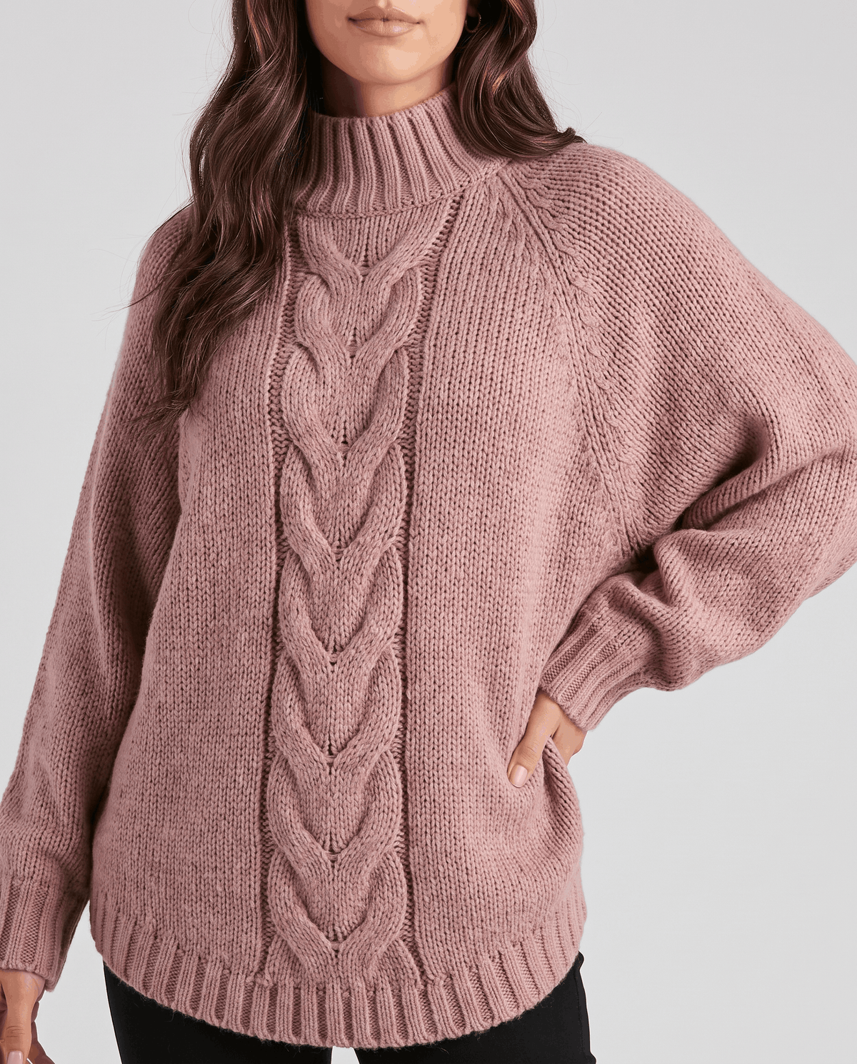 Cropped front view of dusty pink chunky knit with center cable and curved hem
