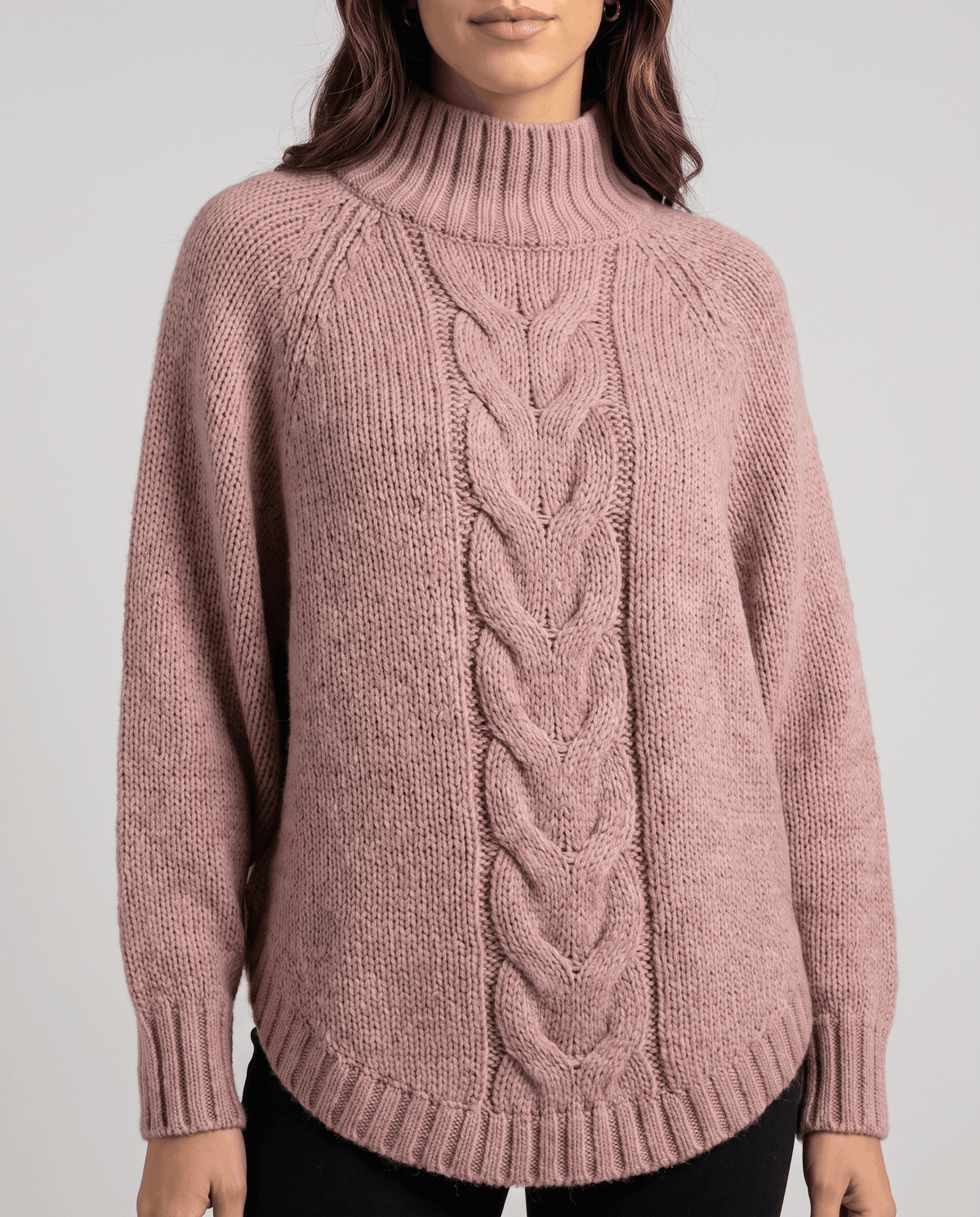 Straight-on front view of pink cable knit sweater with ribbed cuffs and hem