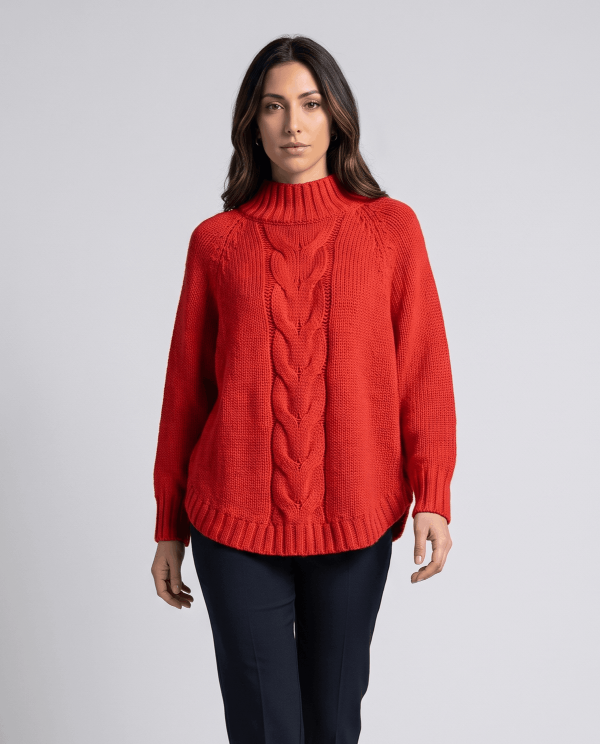 Front view of red batwing turtleneck sweater worn with navy pants