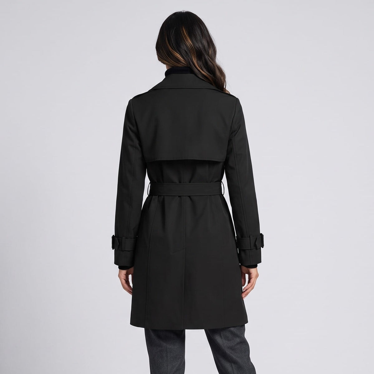 Back view of black coat with belted waist and buckled cuff straps