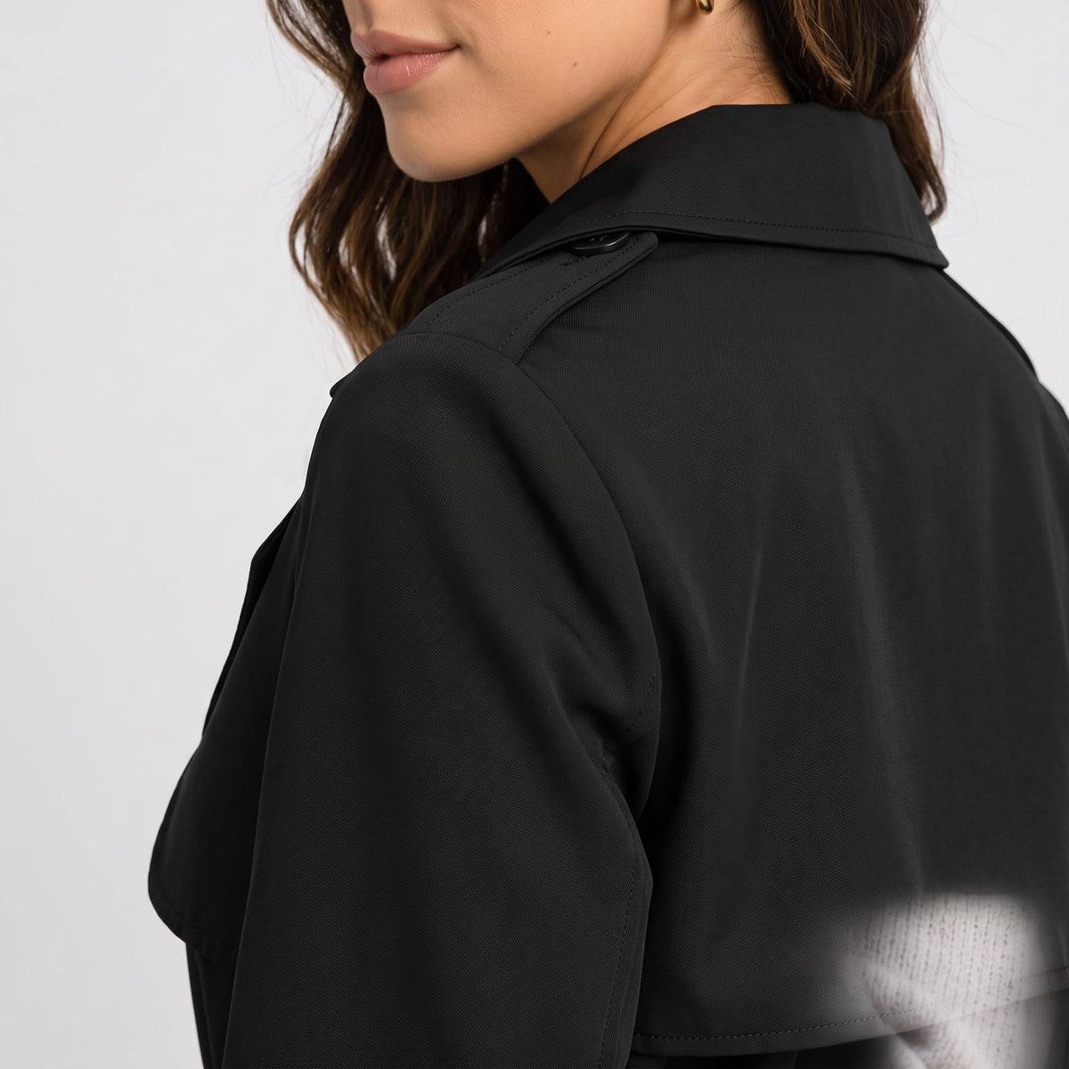 Shoulder detail of black coat showing the epaulette and collar