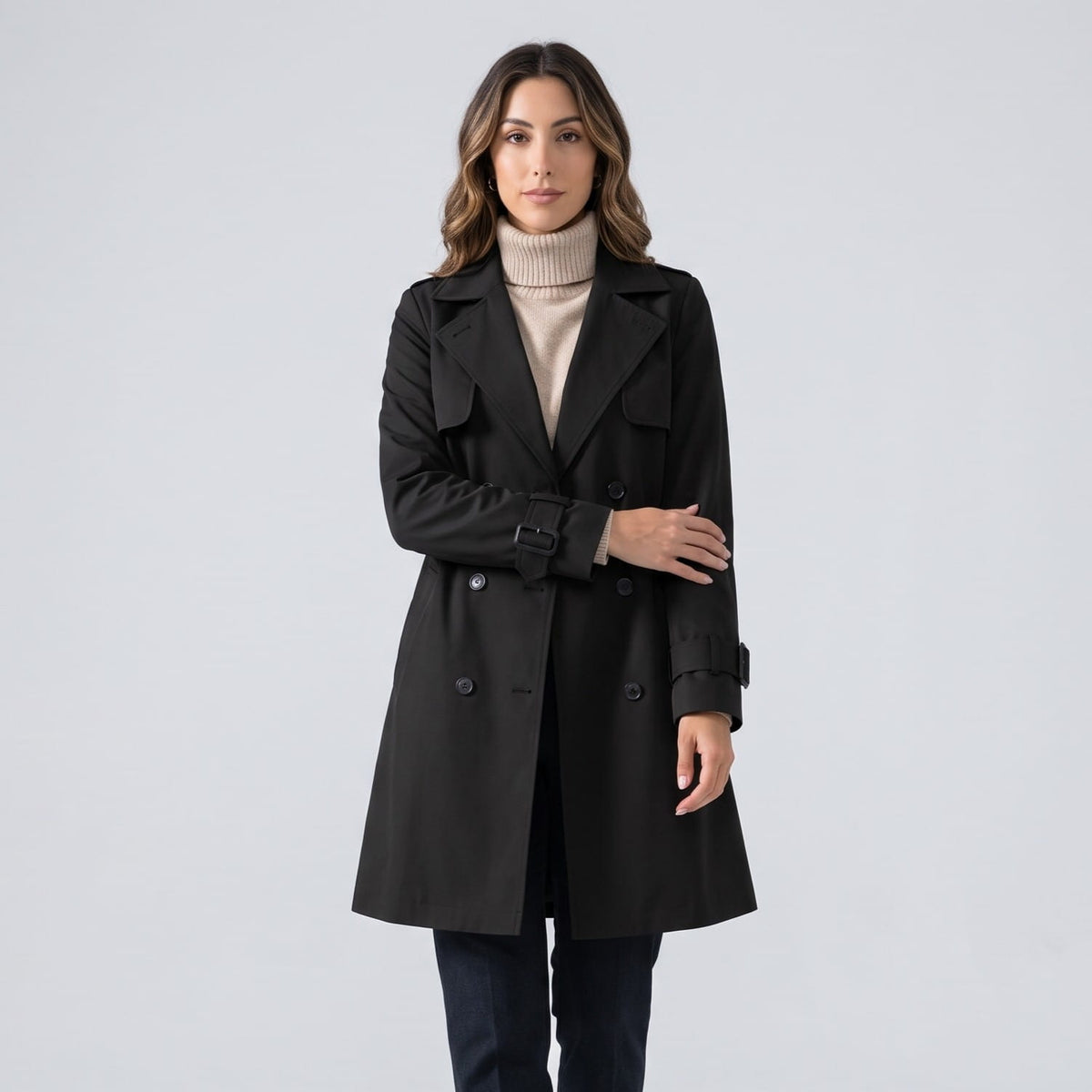 Black coat buttoned over a cream turtleneck and dark jeans, front view