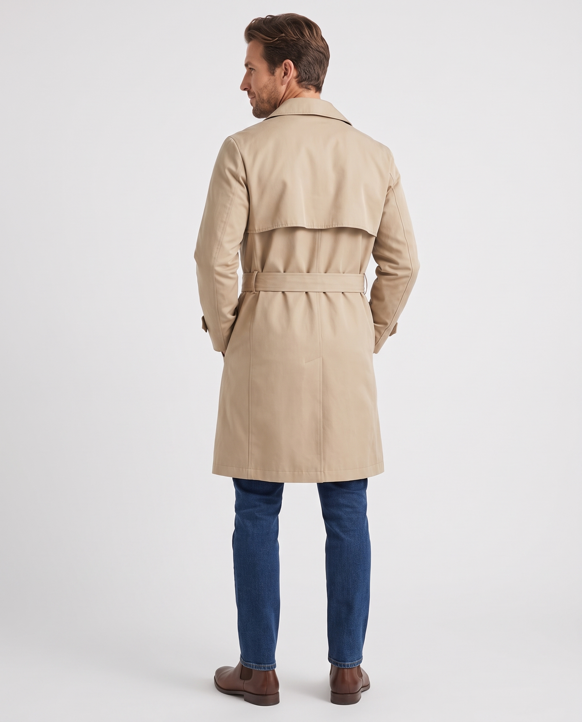 Back view of beige trench coat with storm flap and tie belt, worn with blue jeans