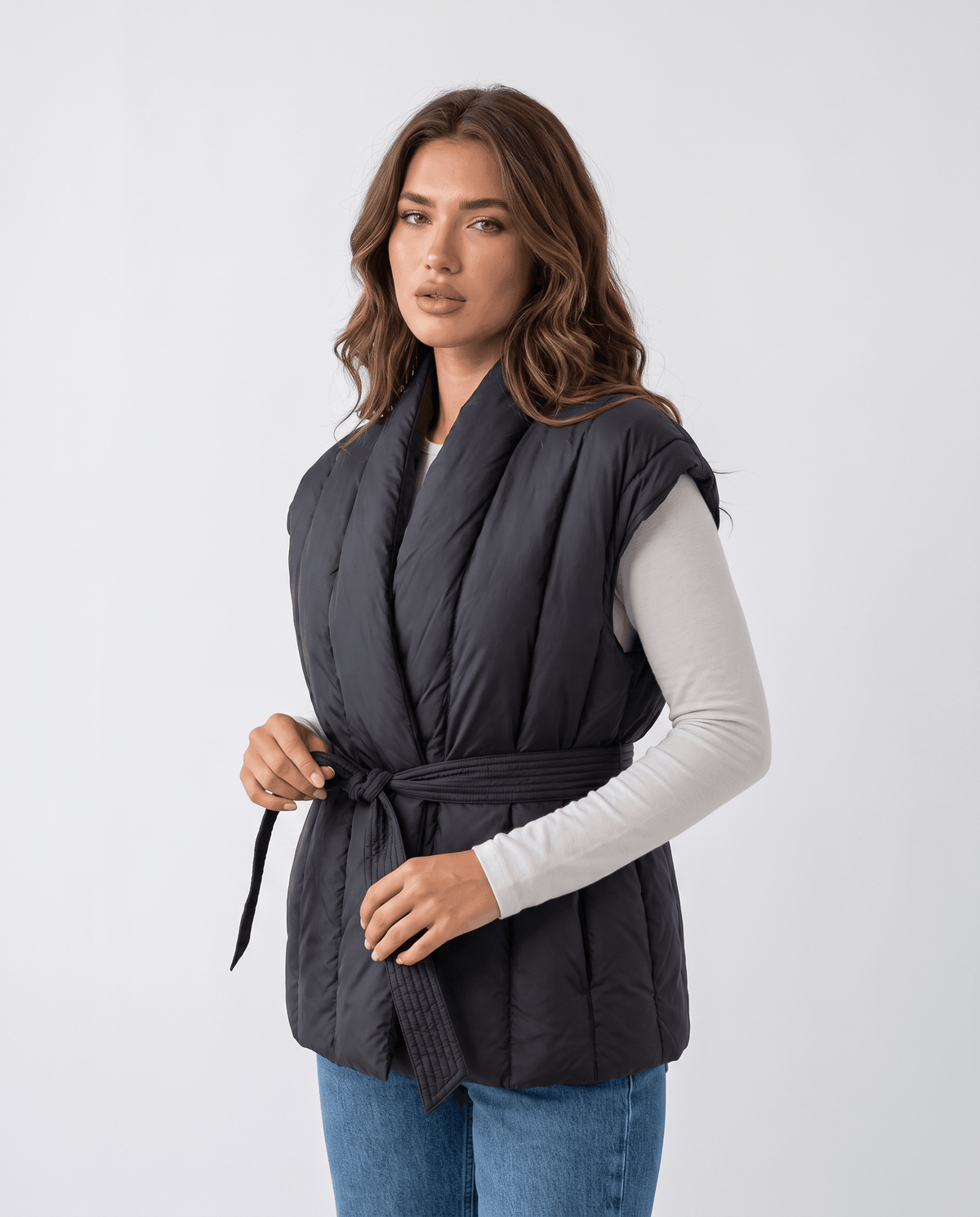 Model in black quilted vest with draped shawl collar, three-quarter front view
