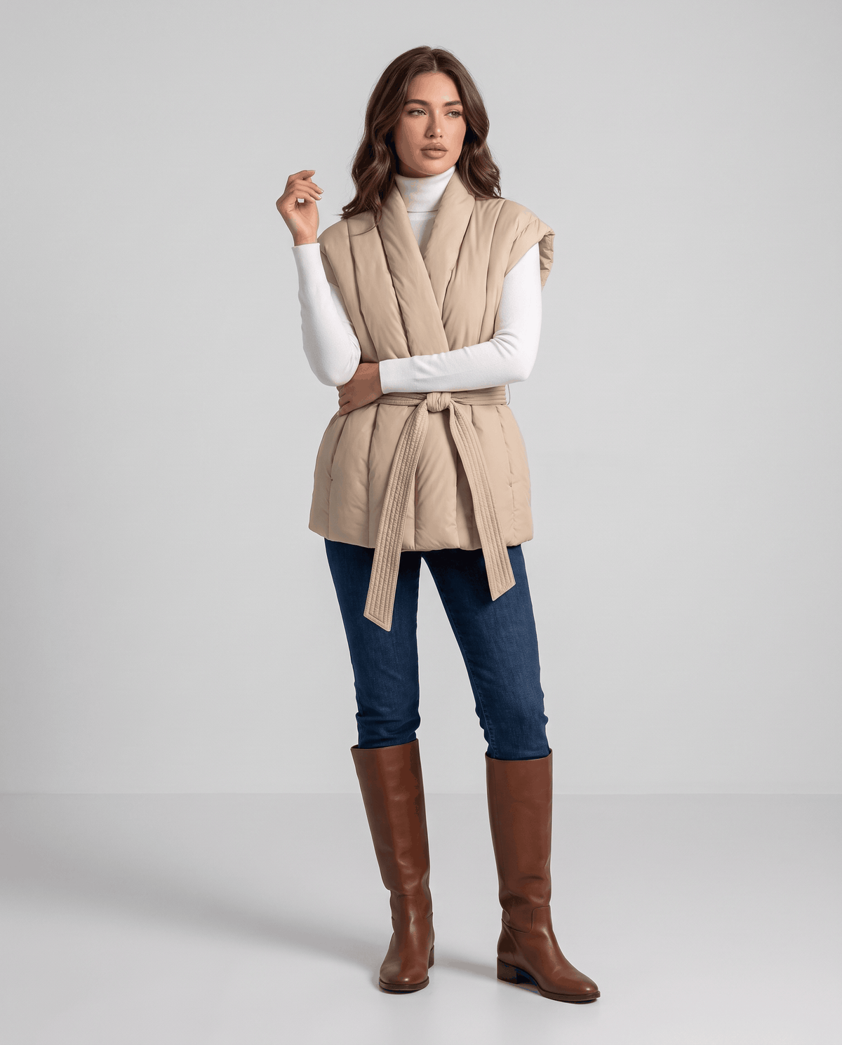 Full-length khaki vest belted at waist, styled with jeans and brown boots