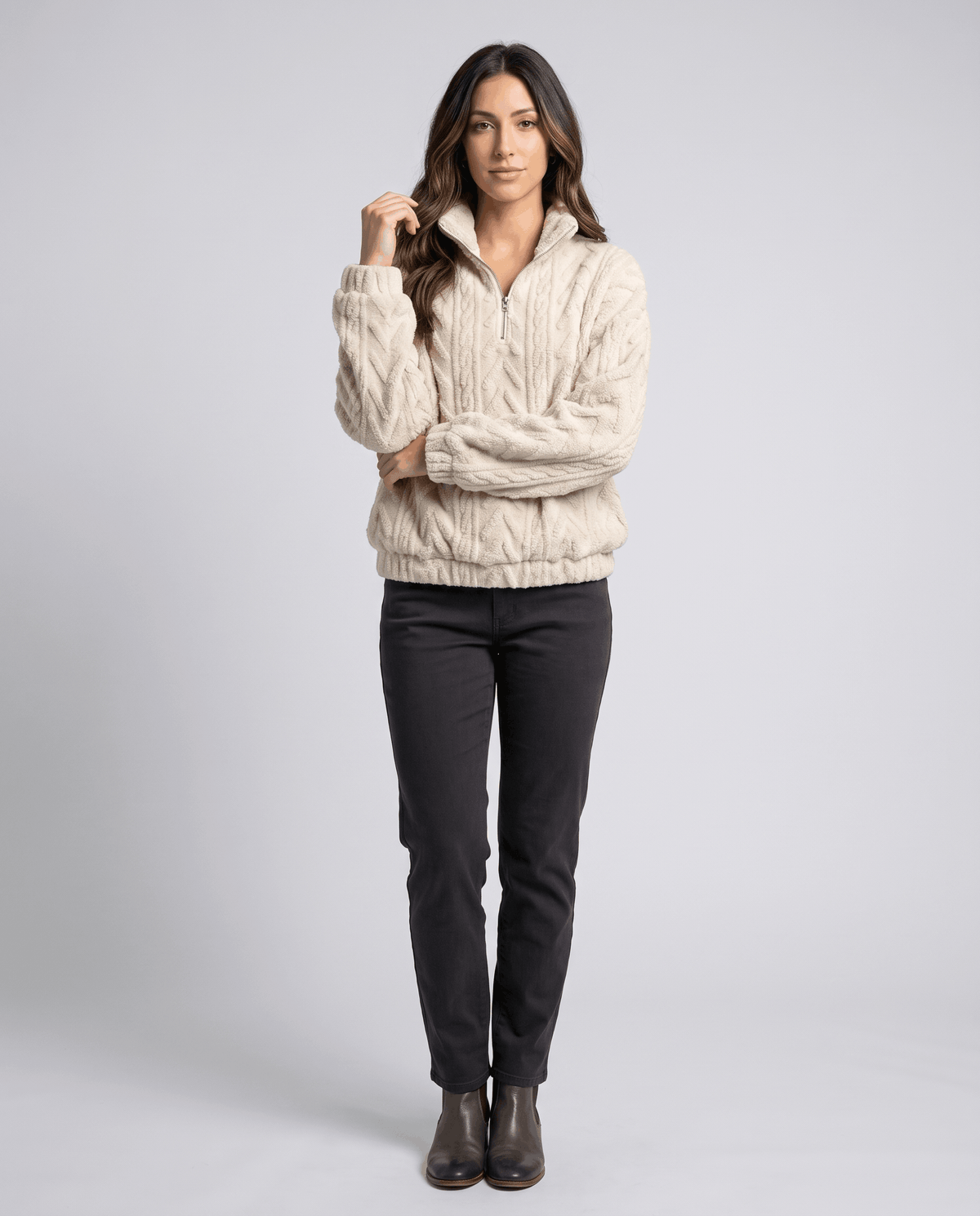 Full-length view of cream quarter-zip pullover with dark jeans and ankle boots