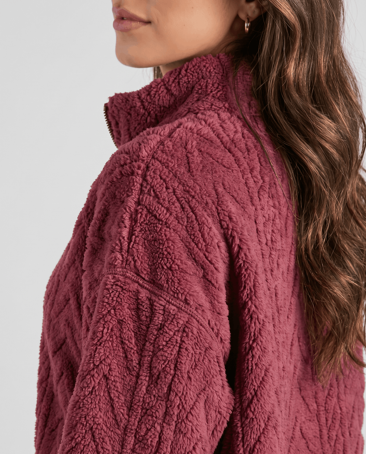 Side shoulder detail of burgundy fleece with embossed cable pattern