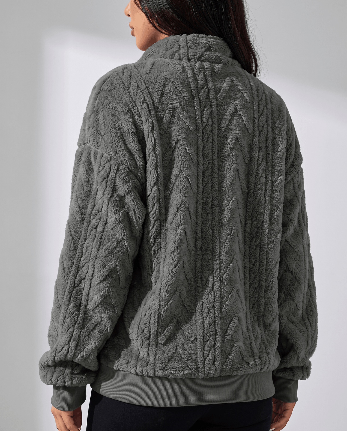 Back view of dark gray fleece pullover with banded cuffs and hem