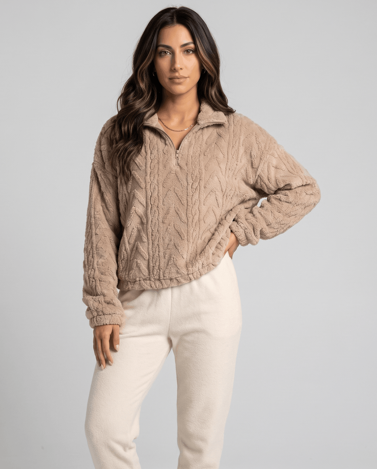 Front view of khaki cable fleece pullover styled with cream pants