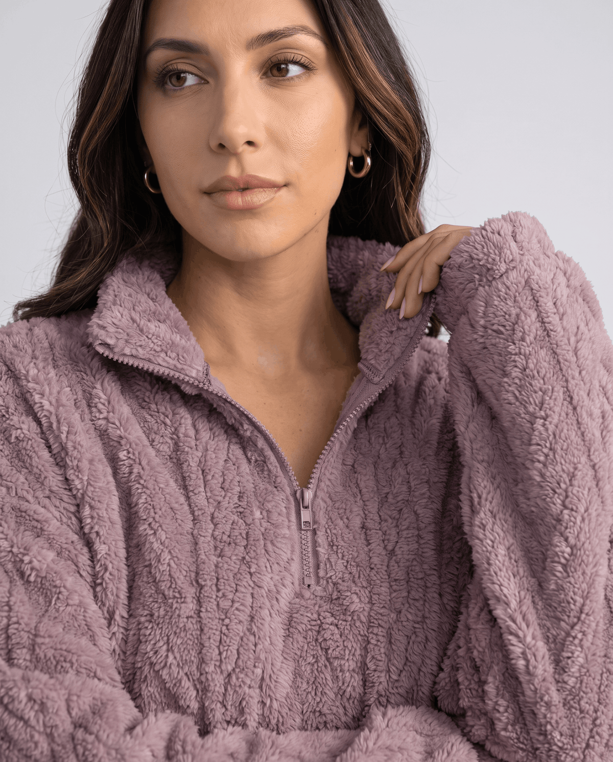 Model with hand at shoulder in a light purple fleece quarter-zip