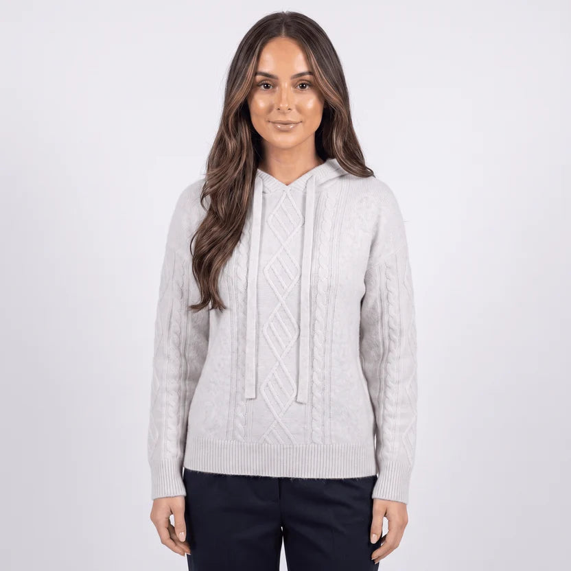 Model in light gray hooded sweater with drawstring and cable texture, front view