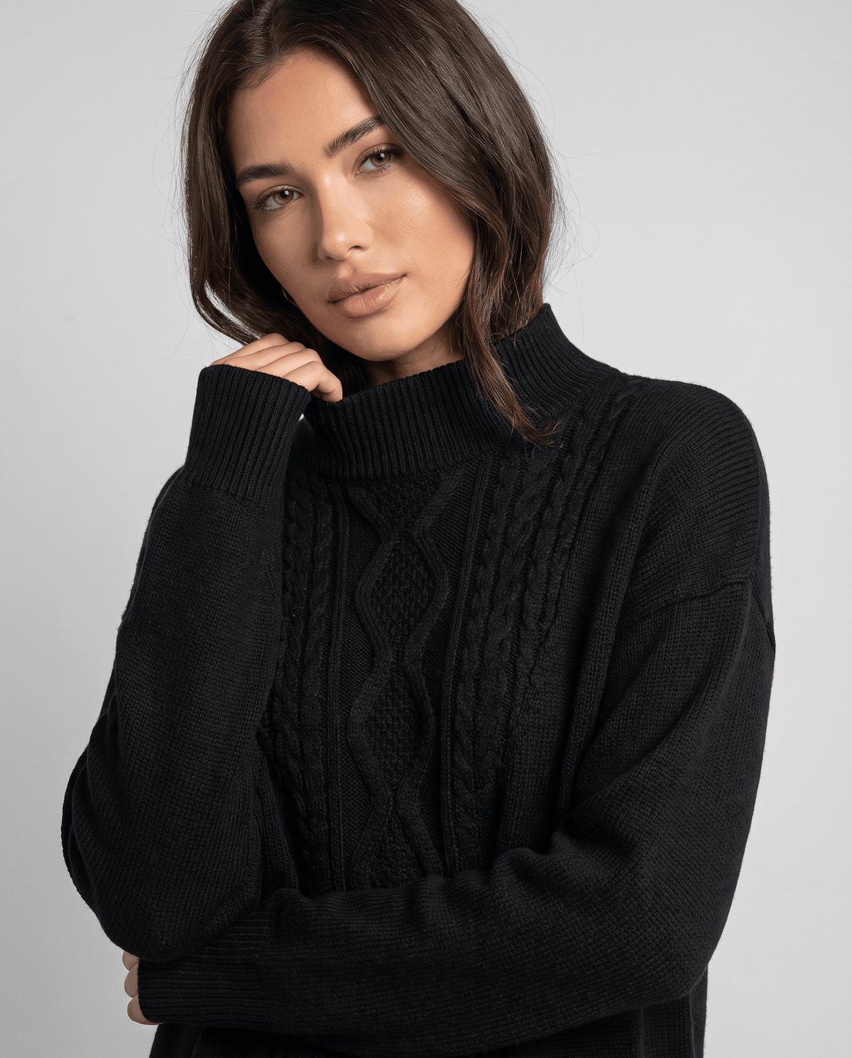 Close-up of the black cable knit pullover and mock neckline